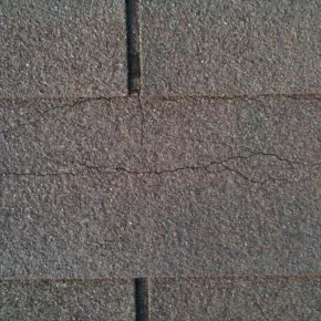Cracked shingles on roof during spring