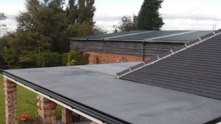 Extended flat roof connected to shingle roof